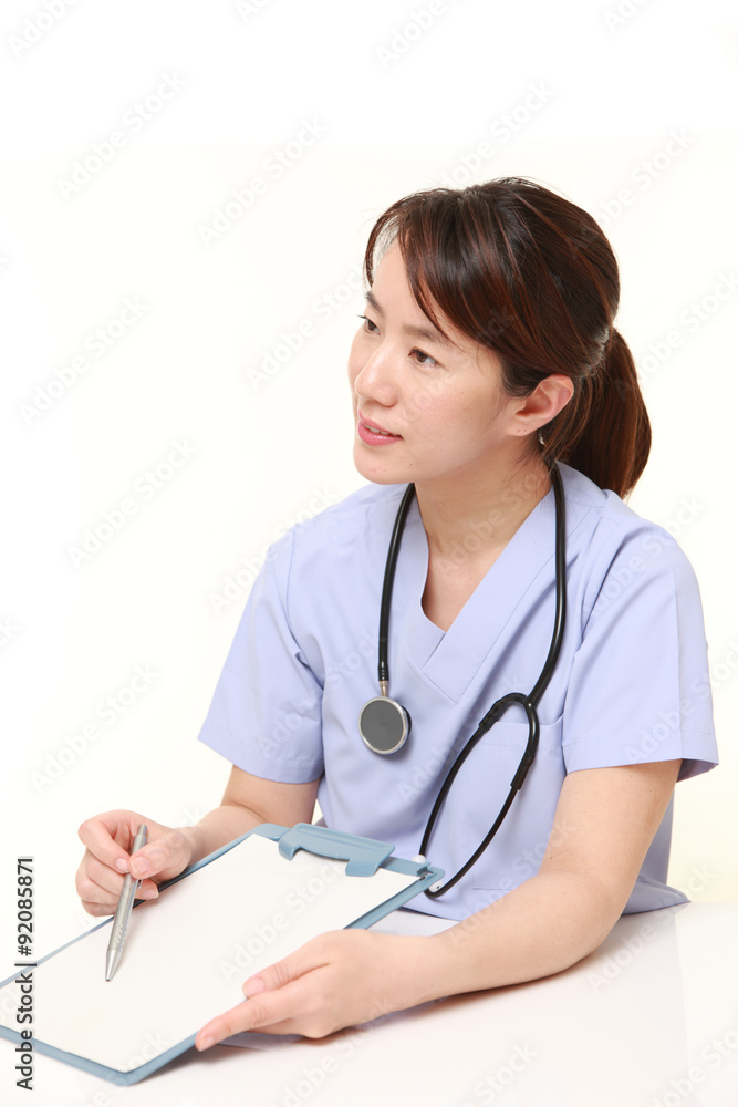 Japanese female doctor with clinical record talks to her patient Japanese female doctor with clinical record talks to her patient