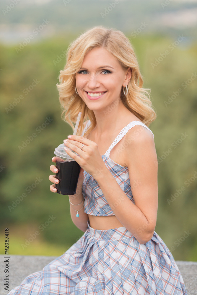 Naklejka premium Girl drinking cocktail outdoors
