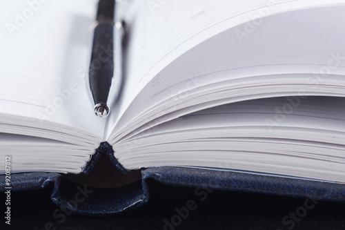 Close-up of open book and pen.