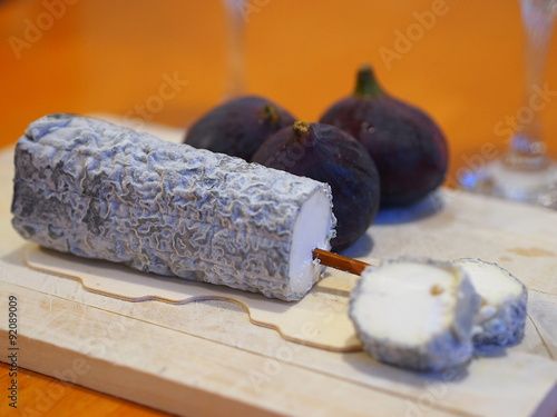 French cheese specialty - Sainte-Maure-de-Touraine fermier- aromatic fungal cheese made of goat's milk. Inside of the cheese is a piece of a straw, which creates a typical frame of this dairy product. photo