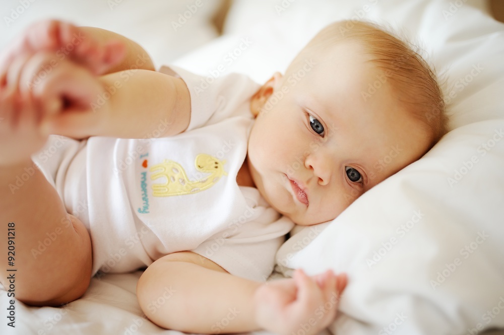 portrait of baby with blue eyes. A child resting on a bed portrait of baby with blue eyes. A child resting on a bed