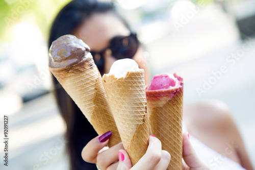 Beautiful young women having fun with ice cream at the park.
