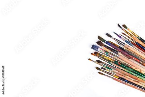 Big set of artist dirty paint brushes on white background with much space for text. Isolated image. 