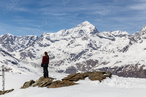 A woman standing on the snow in the background of Matterhorn and snow mountain.