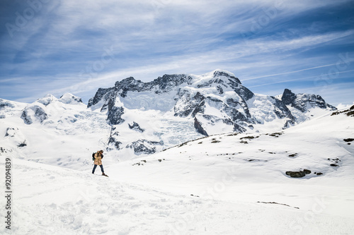A man taking a film camera in the background of snow mountain.