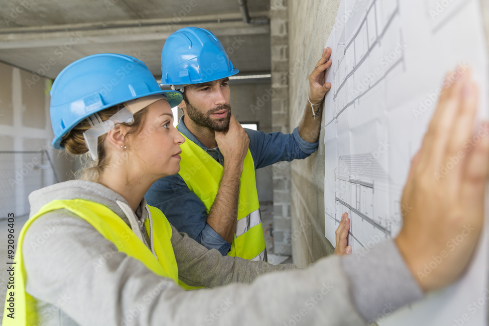 Engineers on building site checking plans Engineers on building site checking plans