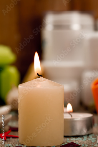 Spa composition with sea salt, candles, soap, shells, creams for face on wooden background. Aromatherapy.