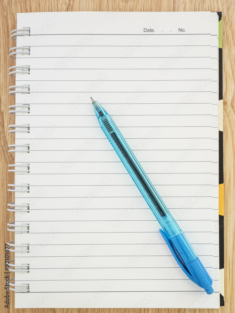 Notebook and pen 1 - Blank notebook and blue pen on wood background Notebook and pen 1 - Blank notebook and blue pen on wood background
