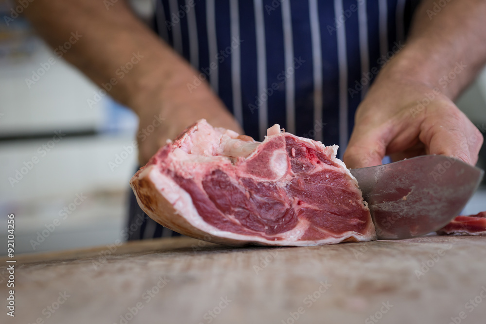 Close up of butcher cutting meat