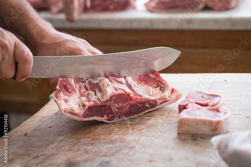 Carving lamb steaks with a large knife