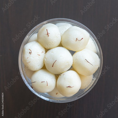 Indian sweetn Rasgulla is a syrupy dessert popular in the Indian subcontinent, and is made out of Indian cottage cheese and sugar syrup photo