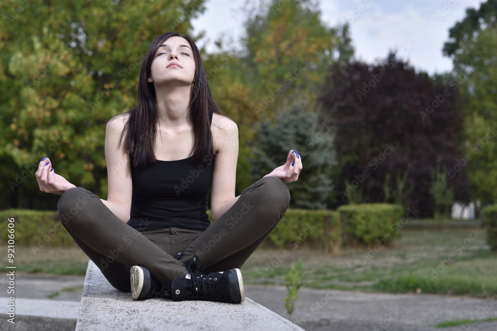 Girl Practicing Meditation in a Park Girl Practicing Meditation in a Park