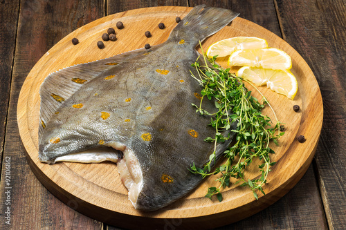 Fototapet Raw plaice with pepper, thyme and lemon on the board