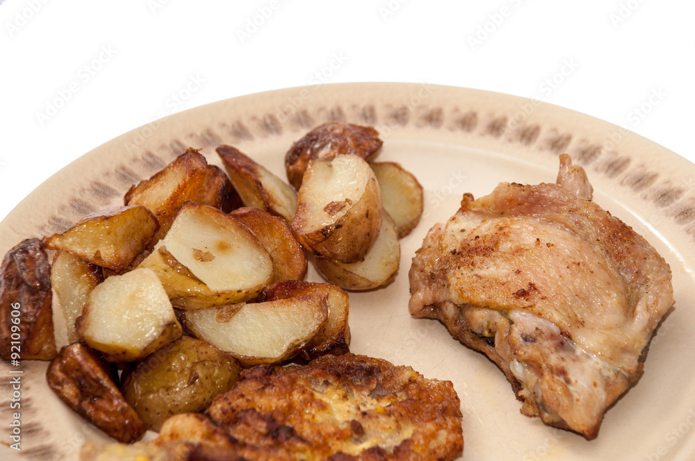 Fried young potatoes and chicken meat on the plate