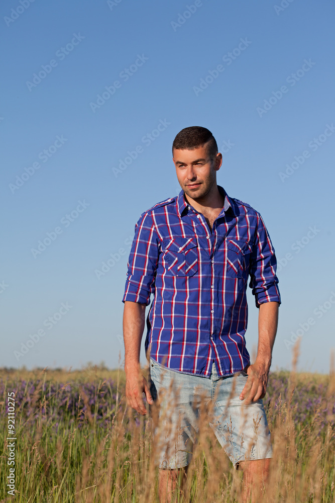 Attractive young man standing in a field Attractive young man standing in a field