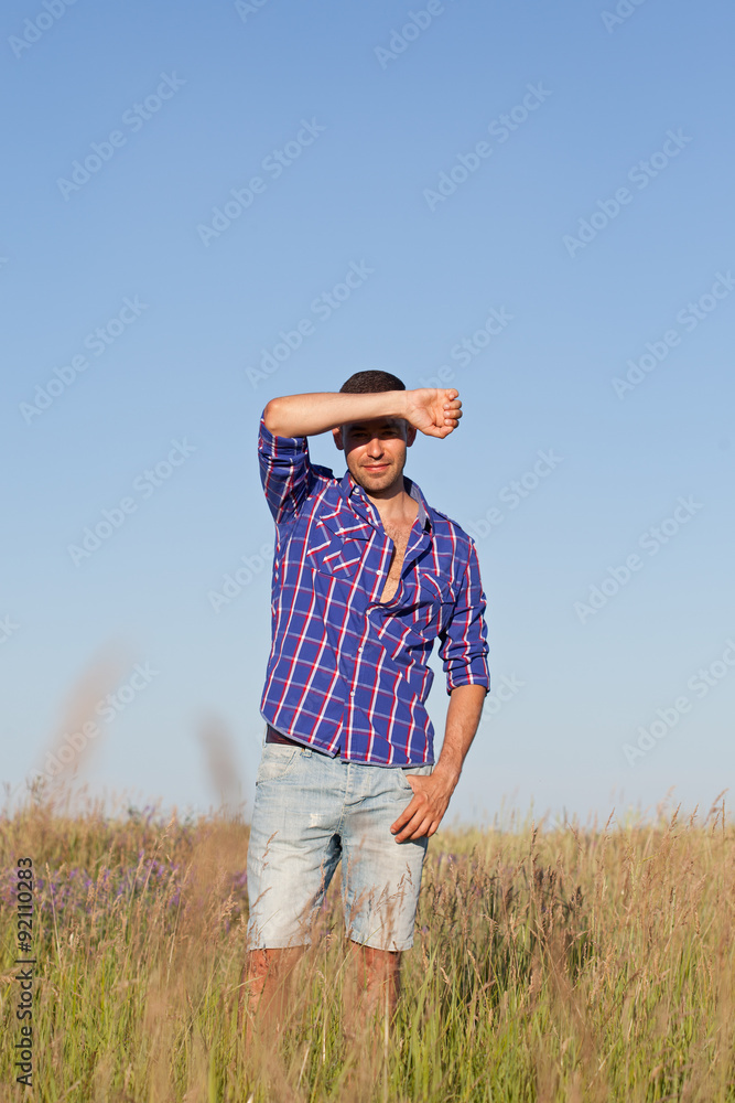 Attractive young man standing in a field
