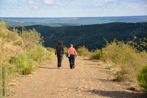 mujeres paseando por un camino de montaña
