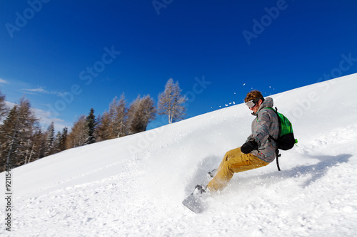 Snowboarder in action on a sunny day in the Italian Alps