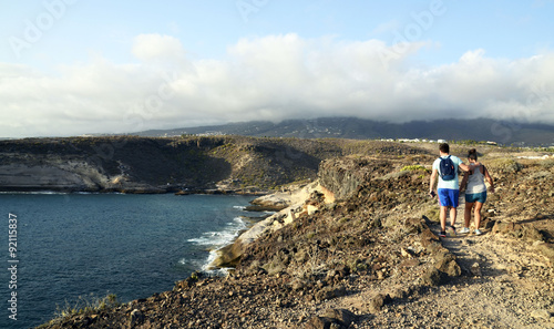 Young couple walking in mountains near the ocean in Tenerife.