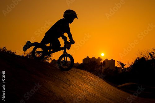 Fototapeta Naklejka Na Ścianę i Meble -  Silhouette Of Stunt Bmx Child Rider - color tone tuned