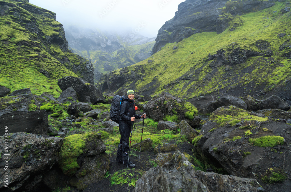 Female hiker in the canyon of national park Eldgja in Iceland on a rainy day.
