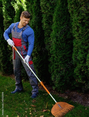 Gardener raking up leaves