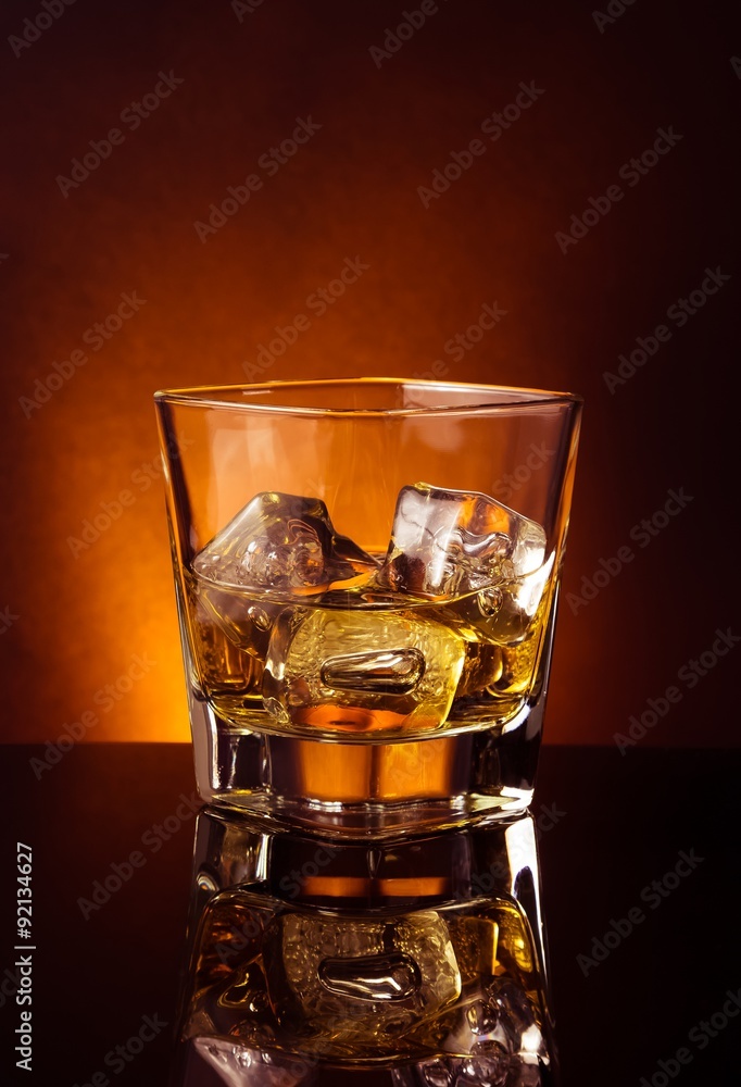 glass of whiskey on black table with reflection, warm tint atmosphere