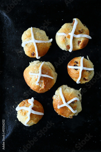 hot cross buns with the glaze on a baking sheet