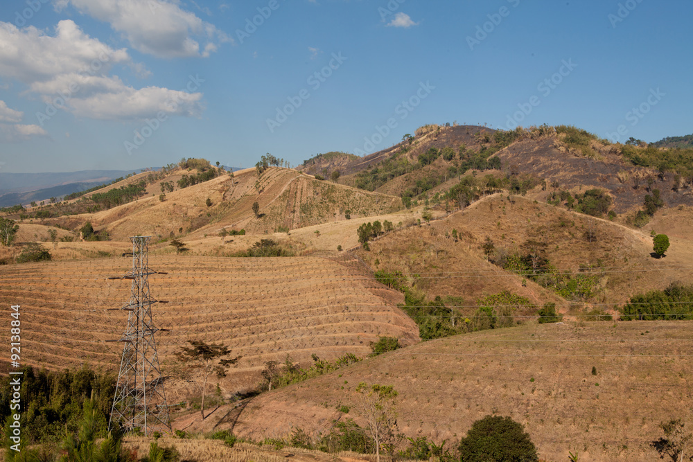 High-voltage transmission towers on top mountains.