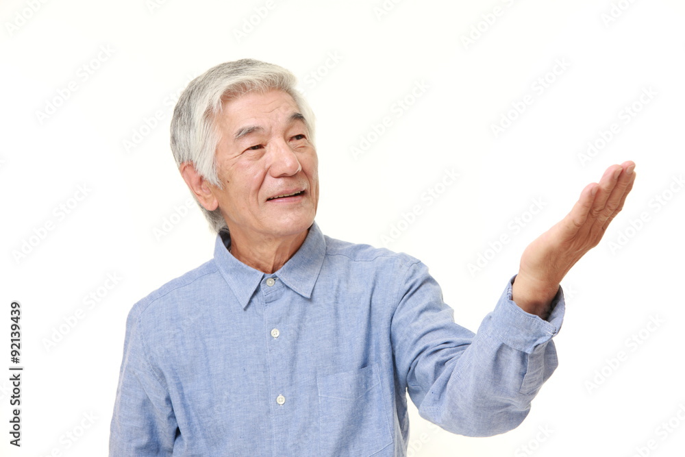 senior Japanese man presenting and showing something senior Japanese man presenting and showing something