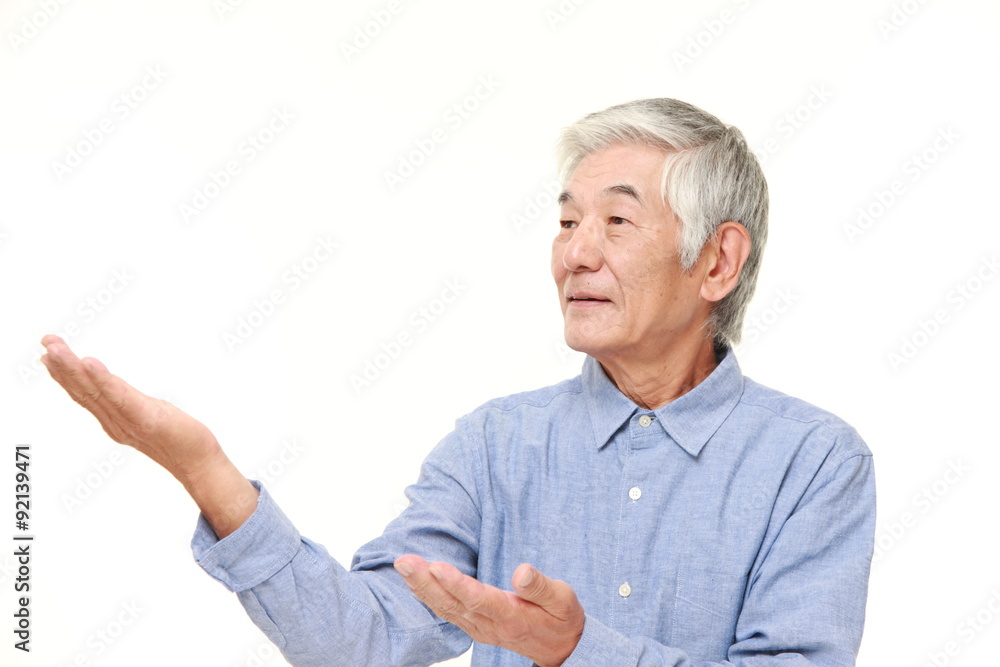 senior Japanese man presenting and showing something senior Japanese man presenting and showing something