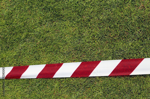 red and white warning tape on the grass photo