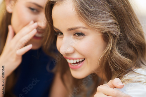 Foto smiling young women gossiping and whispering