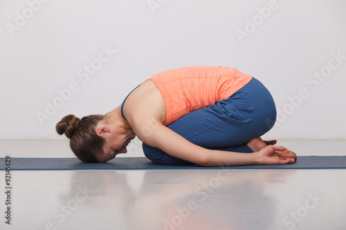 Beautiful sporty fit yogi girl practices yoga asana balasana photo