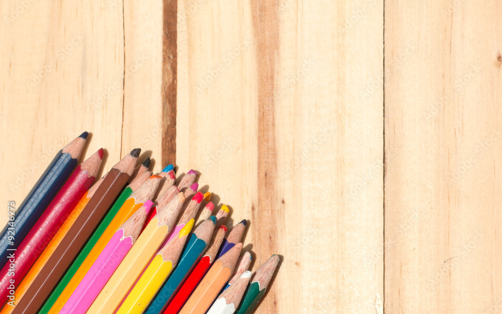 Close up stack colour pencils on wooden background Close up stack colour pencils on wooden background