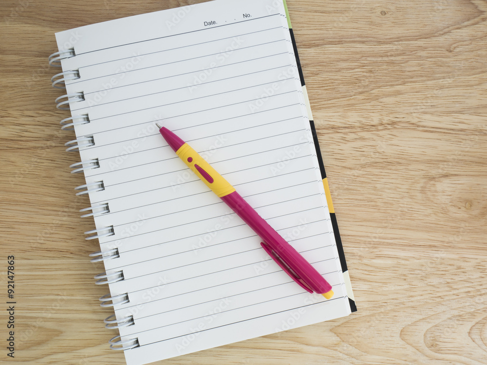 Notebook and pen 3 - Blank notebook and pink pen on wood background Notebook and pen 3 - Blank notebook and pink pen on wood background