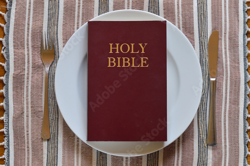 Bible on a dinner plate with silverware in lent