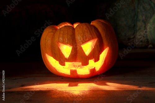 Bright light in pumpkins on wood and pumpkins background.