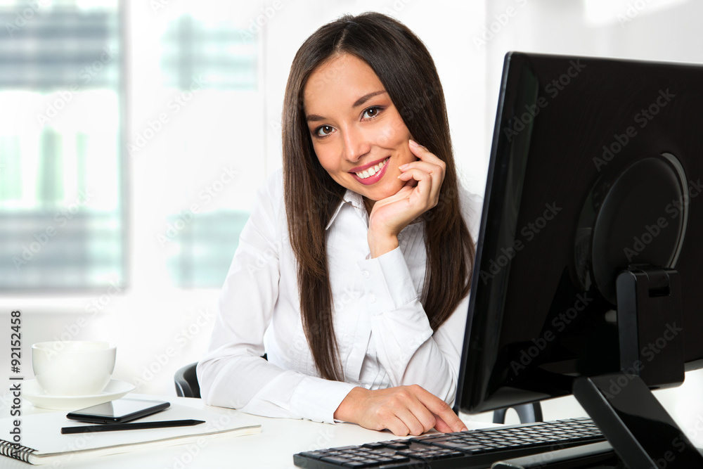 Portrait of a young business woman using computer at office Portrait of a young business woman using computer at office