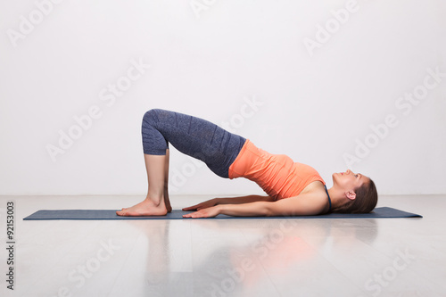 Beautiful sporty fit yogi girl practices yoga asana setu bandhas