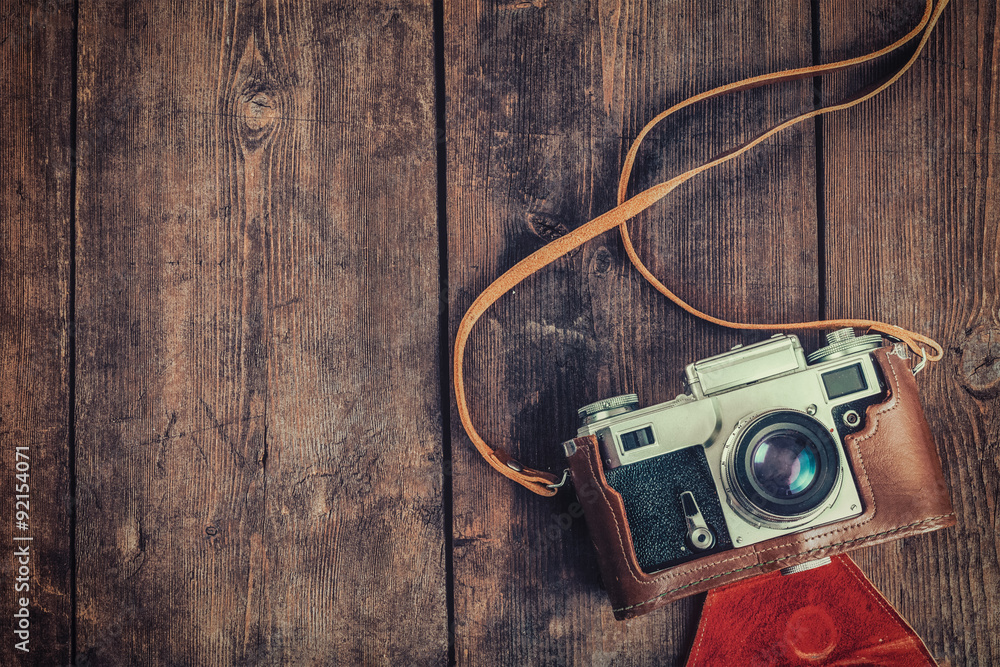 Old retro vintage camera on grunge wooden background