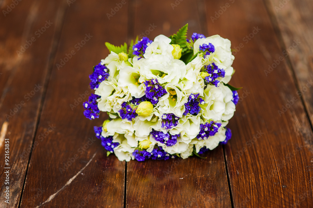 Wedding bouquet of white roses and blue flowers on the table
