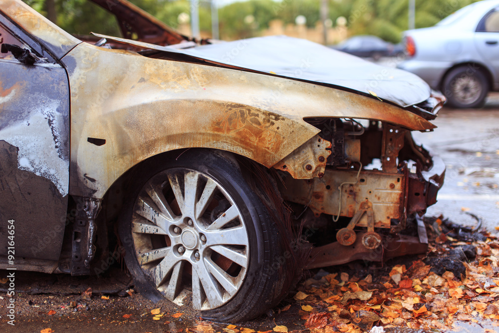 arson out of revenge. burned car parked on the street, close-up arson out of revenge. burned car parked on the street, close-up