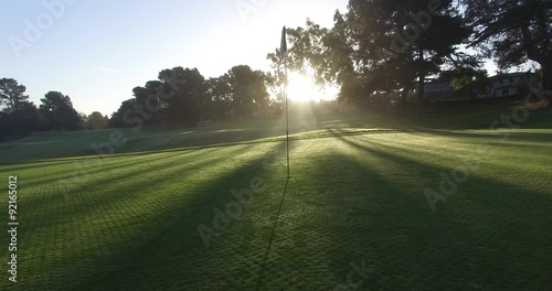 Motion golf course flagstick dramatic beautiful sun rays light shadow gorgeous green early morning 