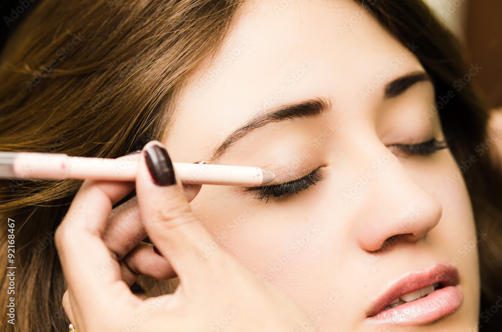 Closeup headshot brunette getting makeup treatment by Closeup headshot brunette getting makeup treatment by