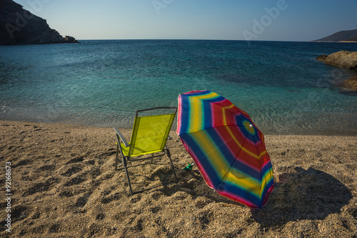 Beach umbrella and chair on a sandy beach Zastani, Evia photo