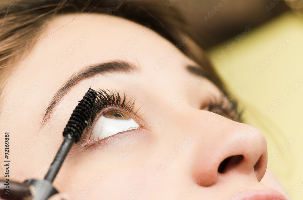 Closeup headshot brunette getting makeup treatment by