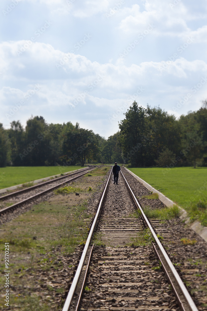 man walking on railroad tracks