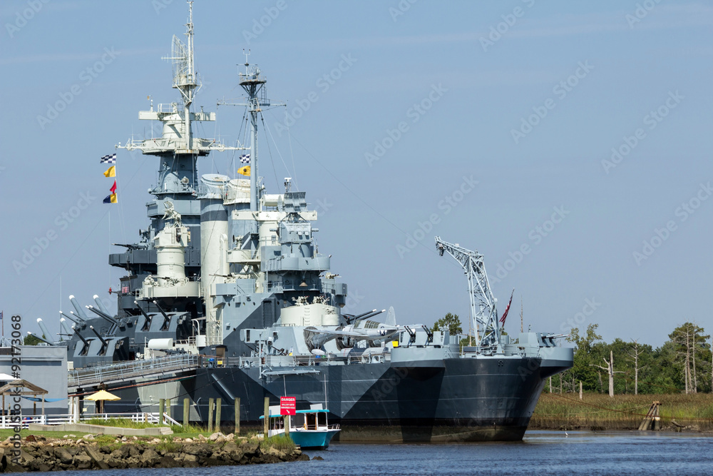 NC Battleship - Gray Multi Tiered Battleship with Guns Communication Equipment and Signaling Flags Docked in Port NC Battleship - Gray Multi Tiered Battleship with Guns Communication Equipment and Signaling Flags Docked in Port