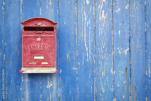 Red mailbox with blue wood background Fototapet